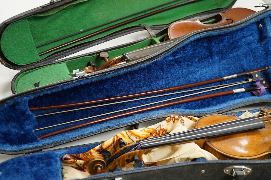 Four cased violins; an early 20th century violin, body 36cm, fitted with a microphone pick up taking a quarter inch jack plug, an early 20th century half size violin, body 32cm, and two student violins. Condition - poor